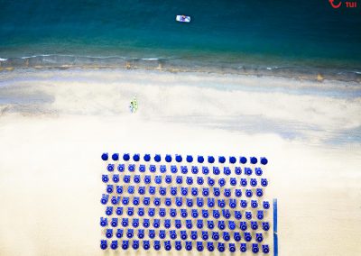 top down view of a beach with blue umbrellas