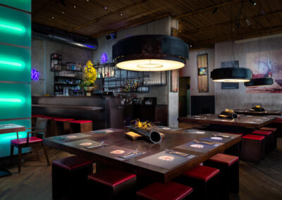 cozy interior of an asian restaurant with red chairs and wall paintings