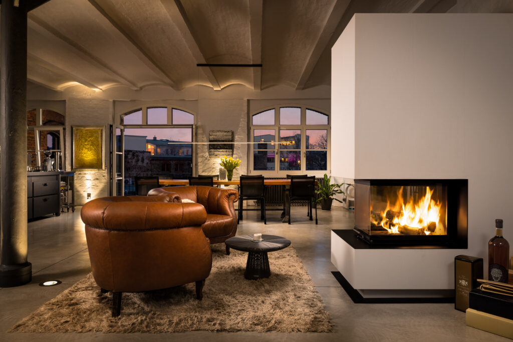 Living room with fireplace in loft at sunset