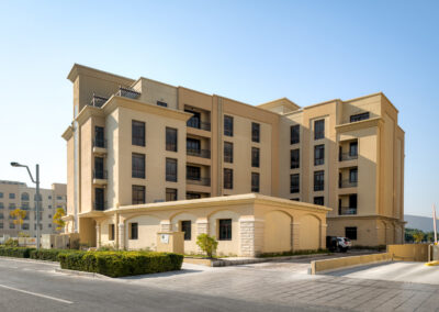 exterior photography of yellow apartment building with a garage entrance