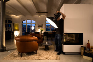 real estate photographer in berlin sets a flash in an apartment for an interior shot