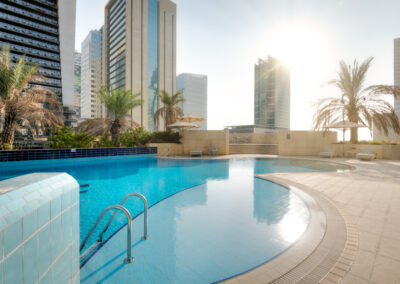 roof top swimming pool with palm trees during sunset