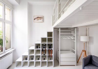 Minimalistisches Loft-Schlafzimmer mit Regalsystem und großer Fensterfront – Architekturfotografie Berlin & Hamburg