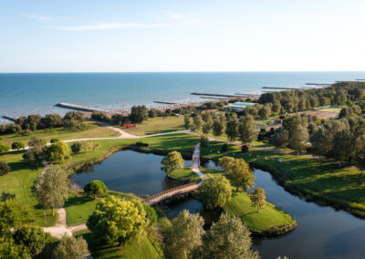 Professionelle Architekturfotografie: Luftaufnahme eines weitläufigen Parks mit See, Holzbrücke und Meerblick – aufgenommen von Tobias Trumpp, Immobilienfotografen-Berlin