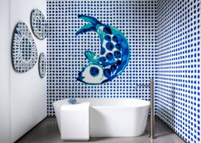 Freistehende Badewanne vor künstlerisch bemalten Wänden