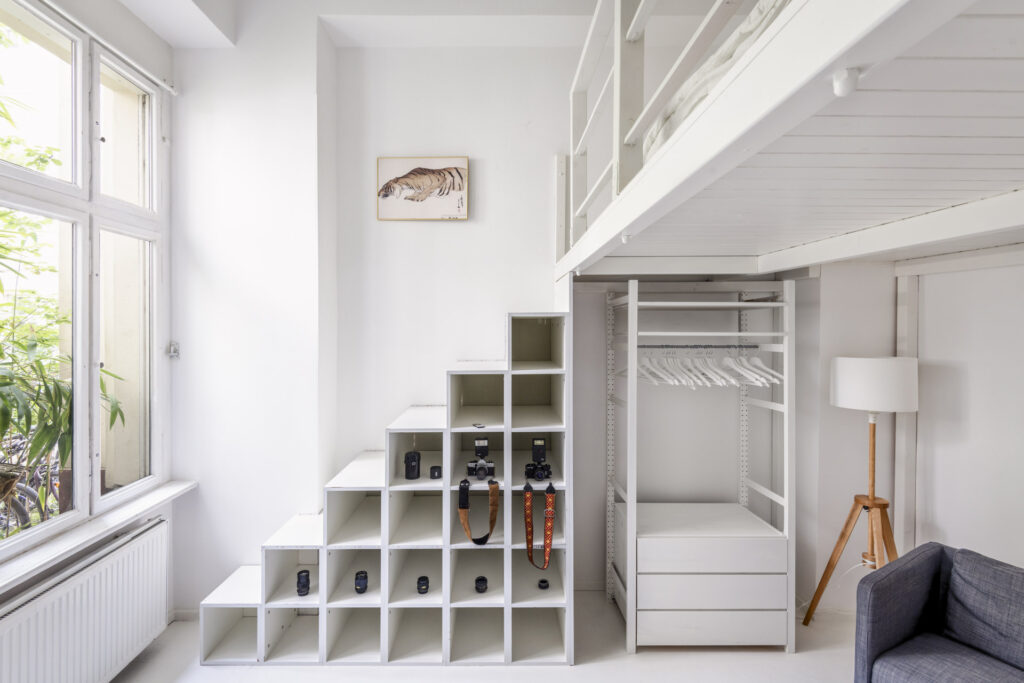 Authentic real estate photography of a bright bedroom with stairs leading to the bunk bed