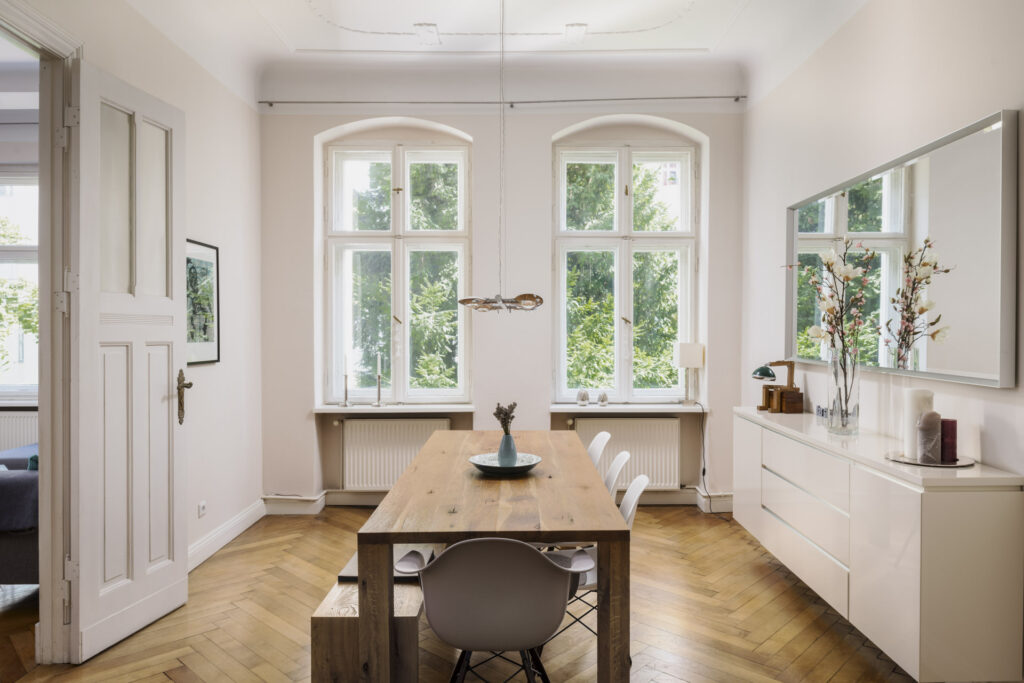 Helles Esszimmer mit großem Holztisch in einem Altbau in Hamburg