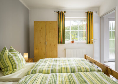 Helles Schlafzimmer mit Doppelbett mit bunter Bettwäsche