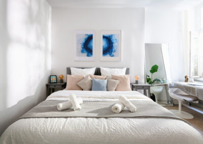 Helles lichtdurchflutetes Schlafzimmer, in dem Licht und Schatten an die Wand neben dem Bett geworfen wird